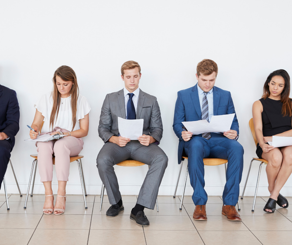 Students sit anxiously outside a job interview