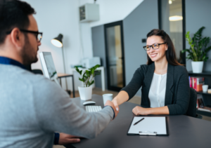 Man and woman shake hands during a teacher interview.